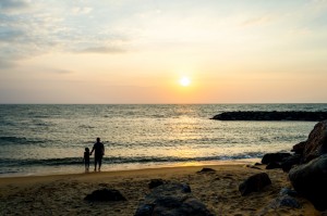 father and daughter at beach sun set