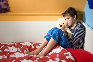 Sad and depressed boy on his bed