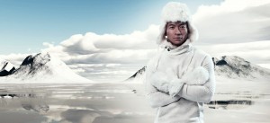 Asian winter fashion man in snow mountain landscape. Wearing white hoody sweater with furry hat and gloves.