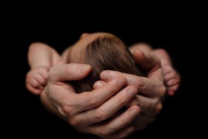 Caring father's hands - dad and newborn