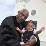 African American Reverend holding baby